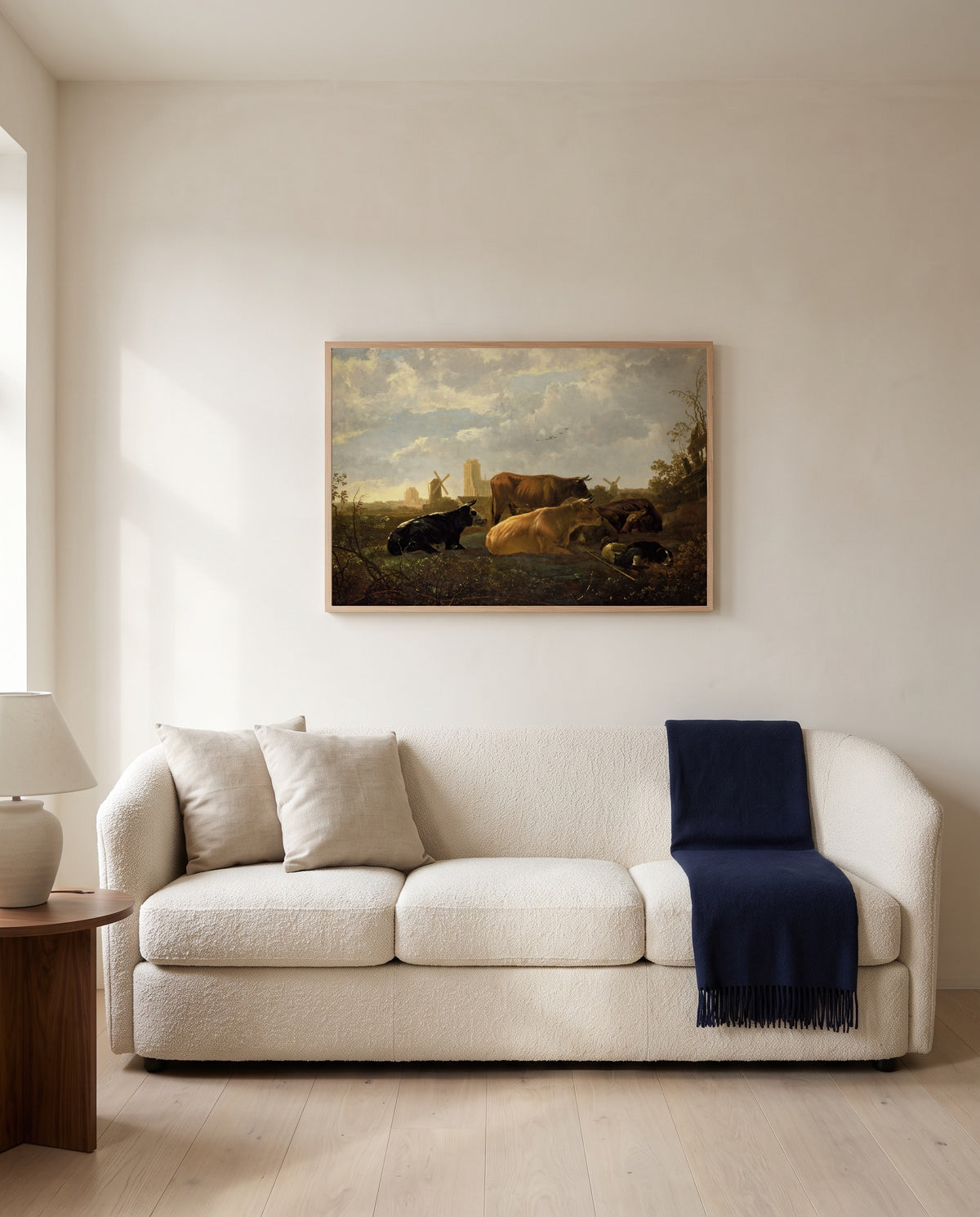 The Small Dort by Aelbert Cuyp framed in natural oak above a cream sofa in a warm living room