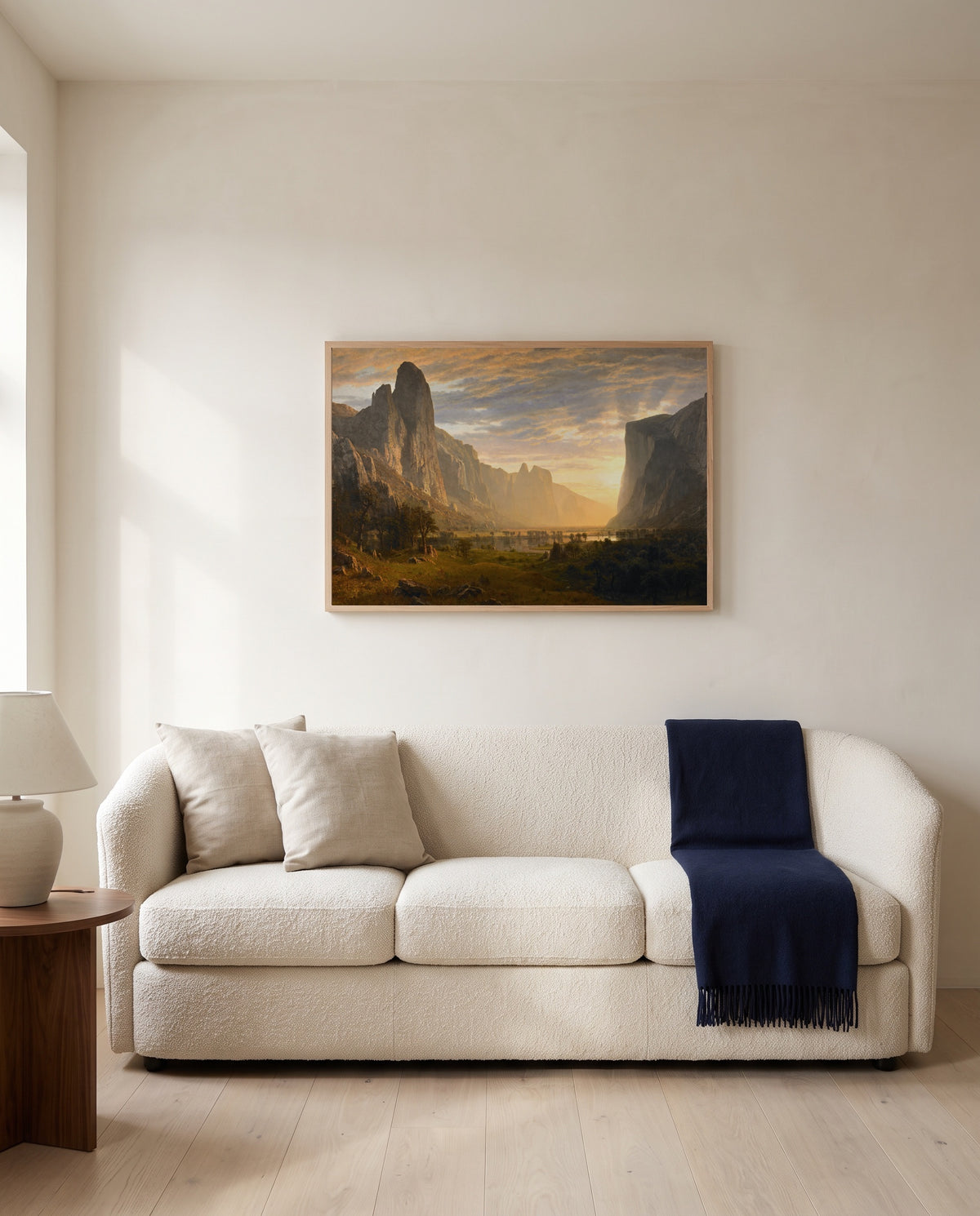 Looking Down Yosemite Valley by Albert Bierstadt framed in natural oak above a cream sofa in a warm living room