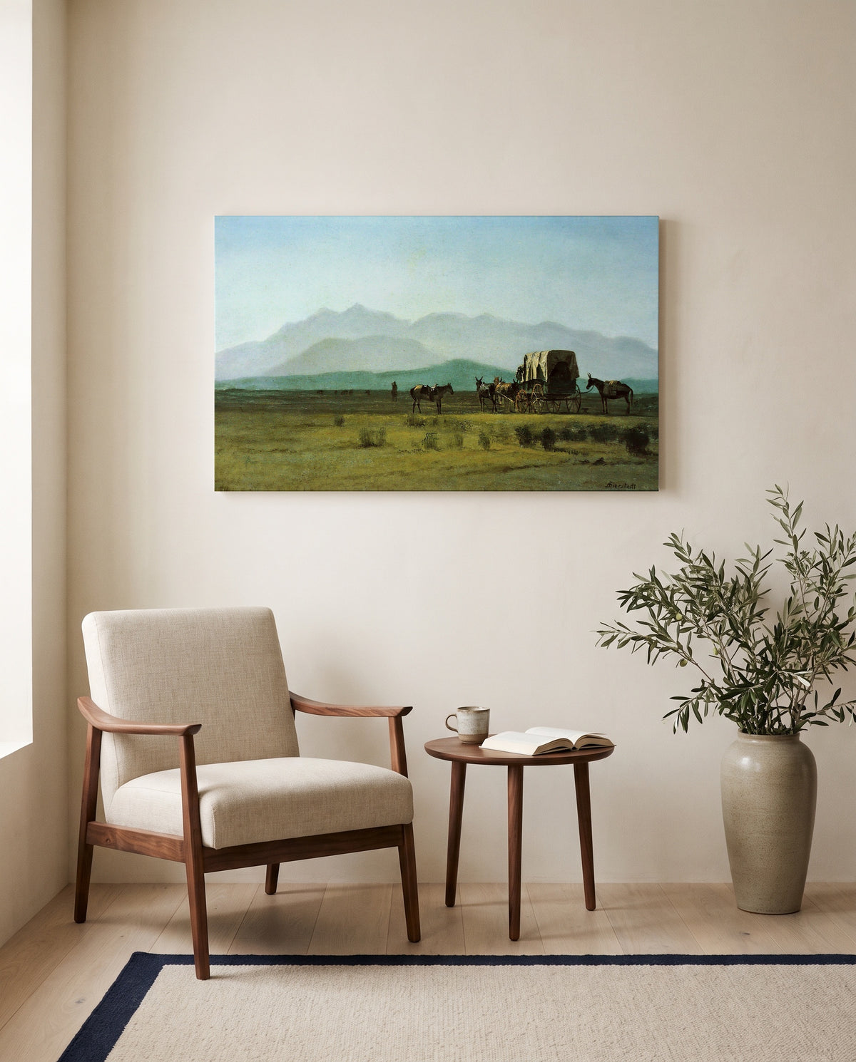 Surveyor’s Wagon in the Rockies by Albert Bierstadt as a stretched canvas above a linen lounge chair in a reading corner
