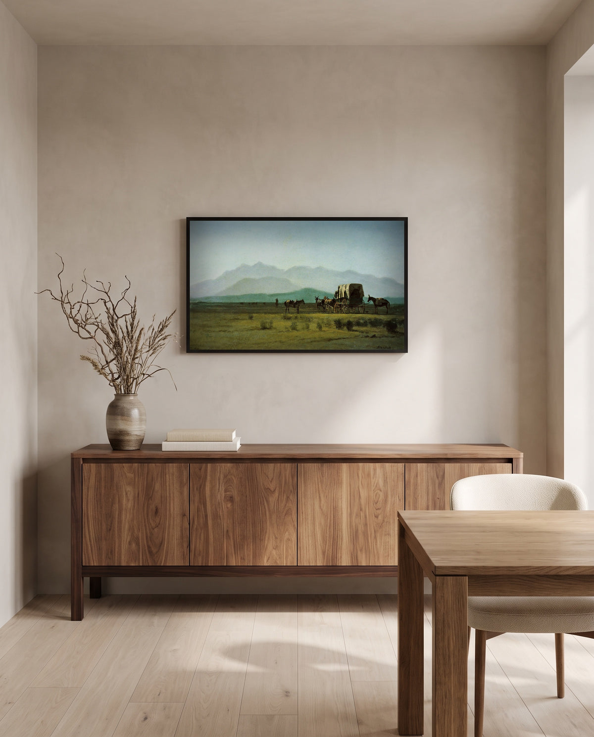 Surveyor’s Wagon in the Rockies by Albert Bierstadt in a black frame above a walnut sideboard in a dining room