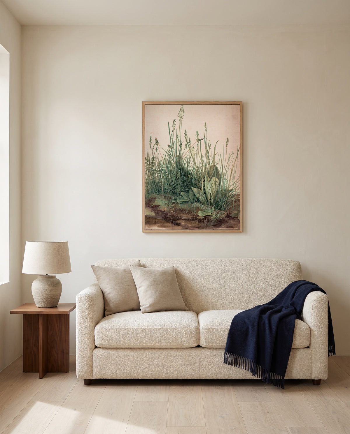 Great Piece of Turf by Albrecht Dürer framed in natural oak above a cream sofa in a warm living room