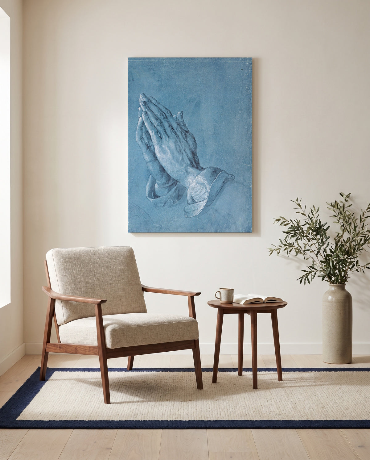 Praying Hands by Albrecht Dürer as a stretched canvas above a linen lounge chair in a reading corner