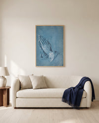 Praying Hands by Albrecht Dürer framed in natural oak above a cream sofa in a warm living room