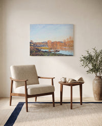 Autumn near Bougival by Alfred Sisley as a stretched canvas above a linen lounge chair in a reading corner
