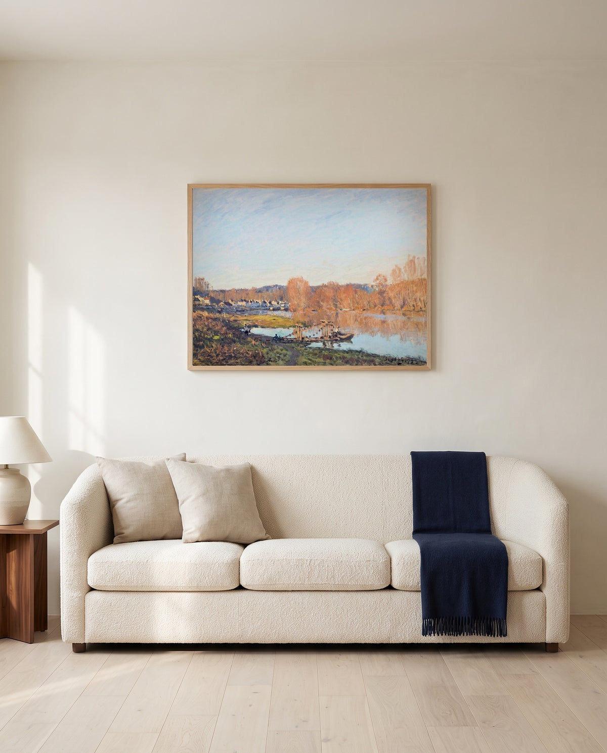Autumn near Bougival by Alfred Sisley framed in natural oak above a cream sofa in a warm living room