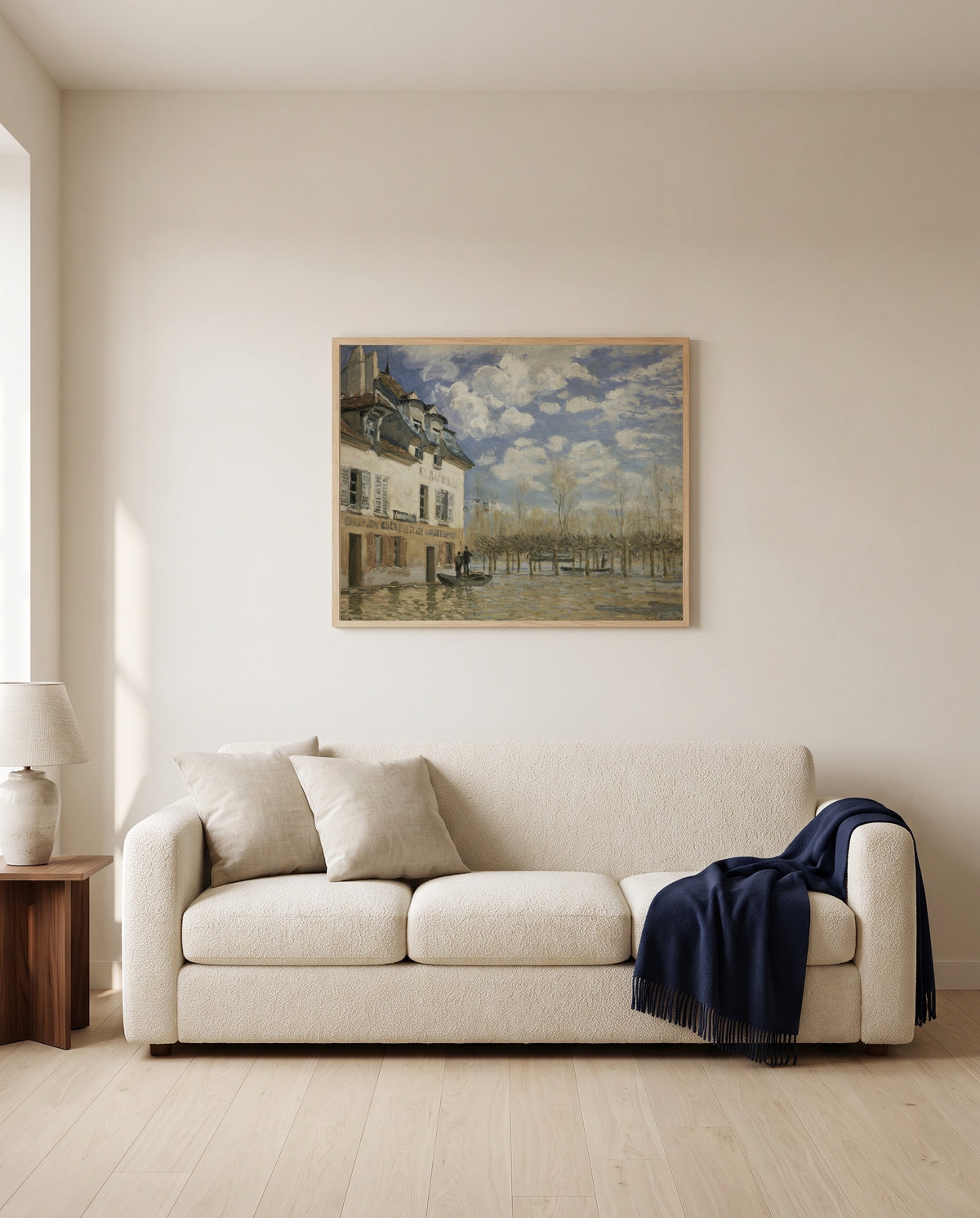 Boat in the Flood by Alfred Sisley framed in natural oak above a cream sofa in a warm living room