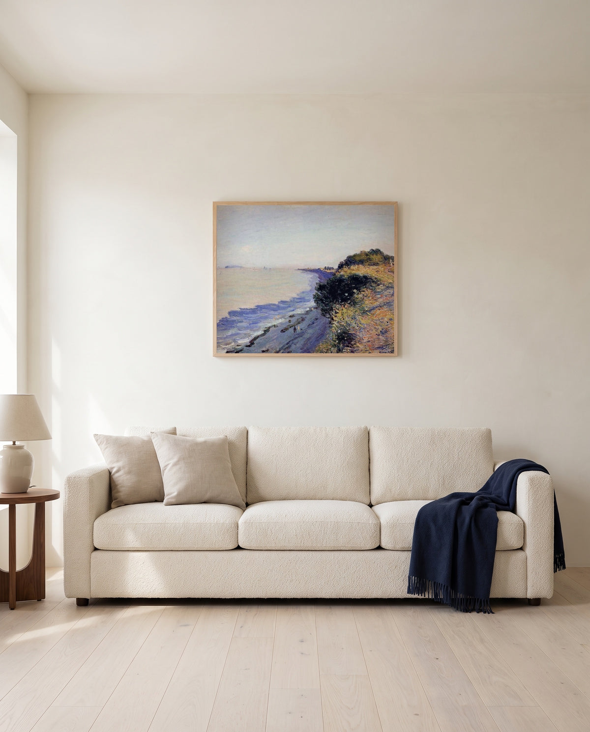 Bristol Channel, Evening by Alfred Sisley framed in natural oak above a cream sofa in a warm living room