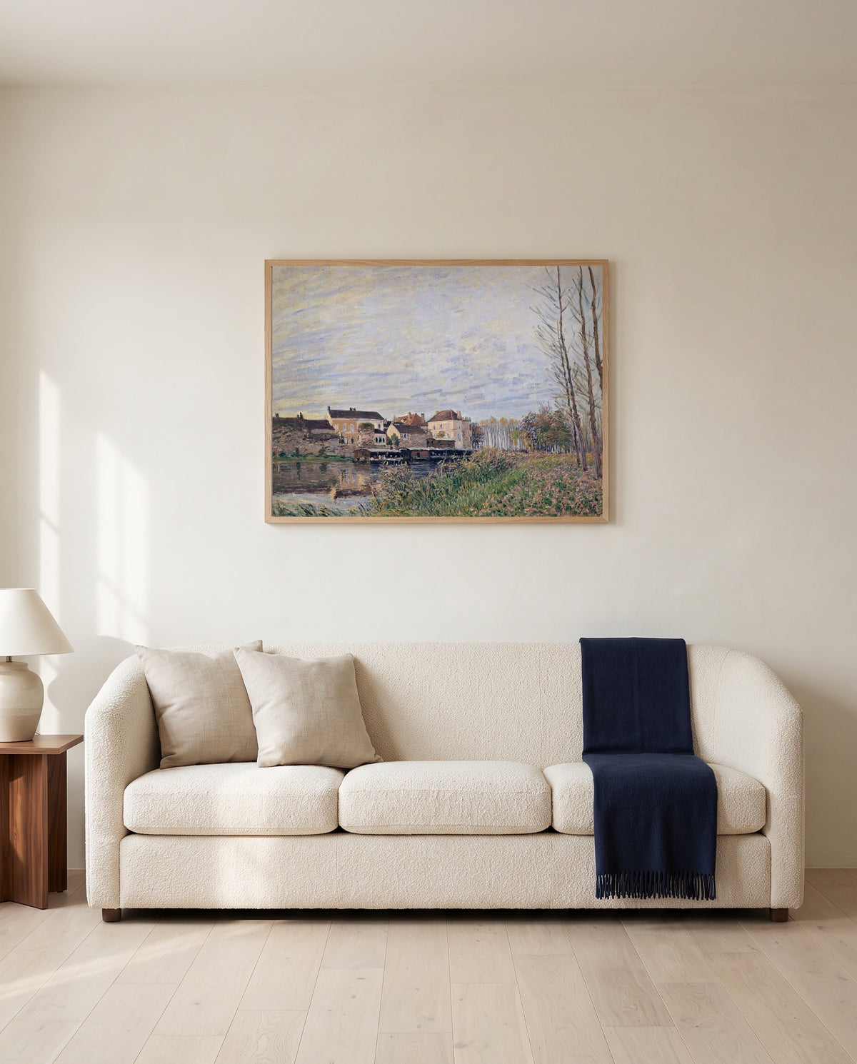 Evening in Moret by Alfred Sisley framed in natural oak above a cream sofa in a warm living room