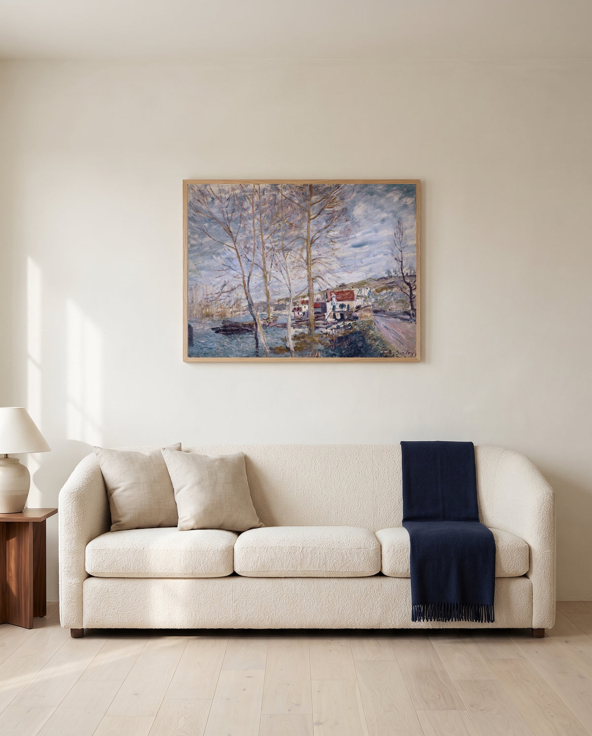 Flood at Moret by Alfred Sisley framed in natural oak above a cream sofa in a warm living room