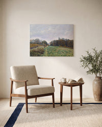Landscape at Louveciennes by Alfred Sisley as a stretched canvas above a linen lounge chair in a reading corner