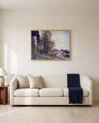 Near Moret-sur-Loing by Alfred Sisley framed in natural oak above a cream sofa in a warm living room