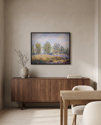 Poplars on a River Bank by Alfred Sisley in a black frame above a walnut sideboard in a dining room