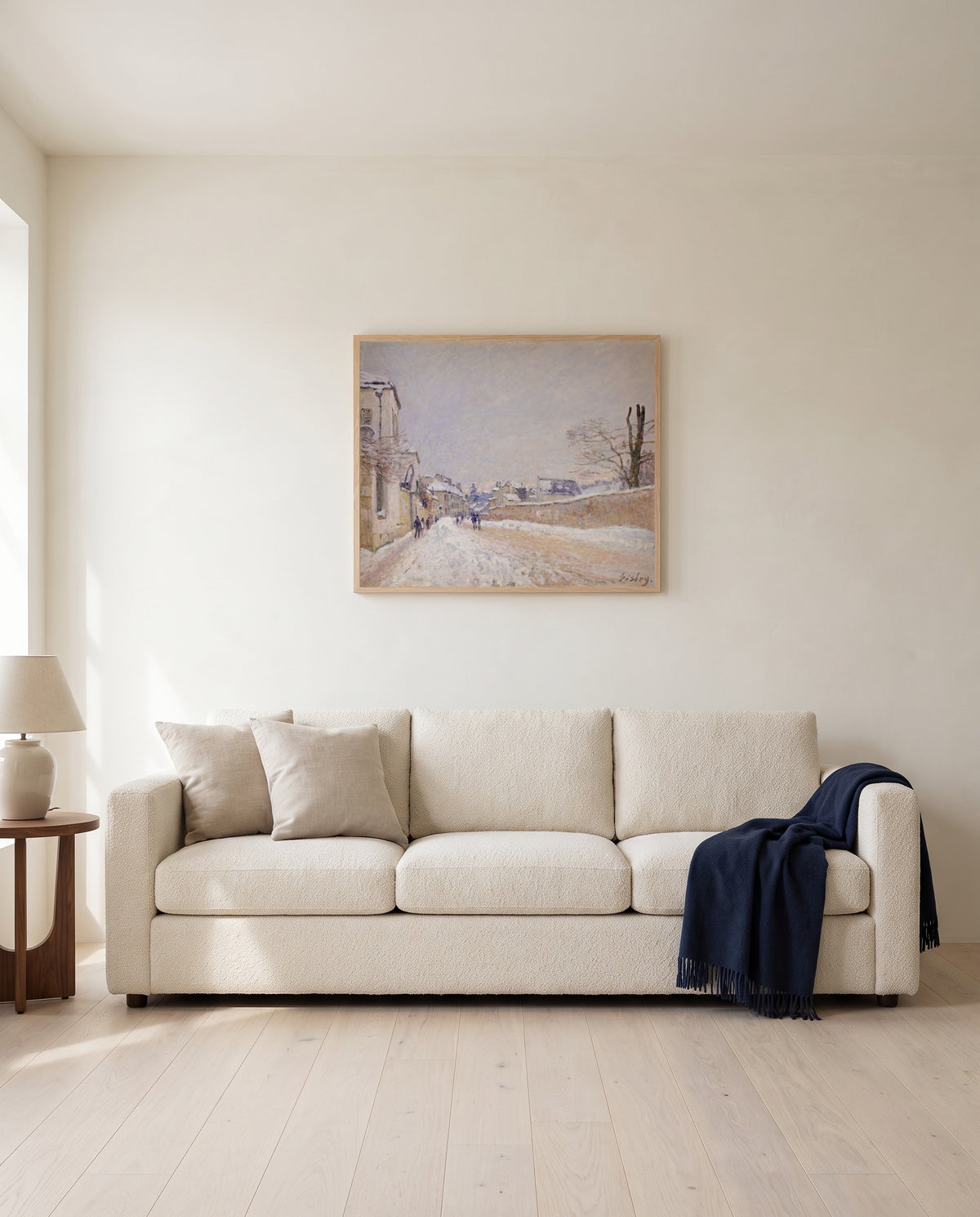 Moret in Winter by Alfred Sisley framed in natural oak above a cream sofa in a warm living room