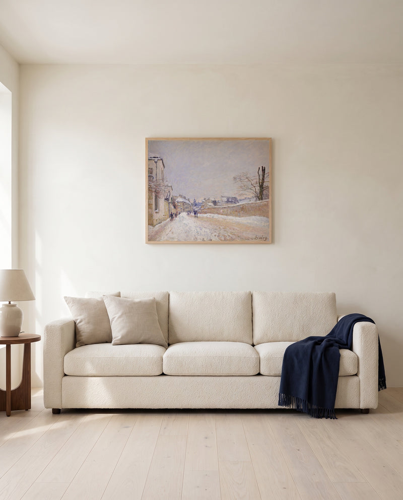 Moret in Winter by Alfred Sisley framed in natural oak above a cream sofa in a warm living room