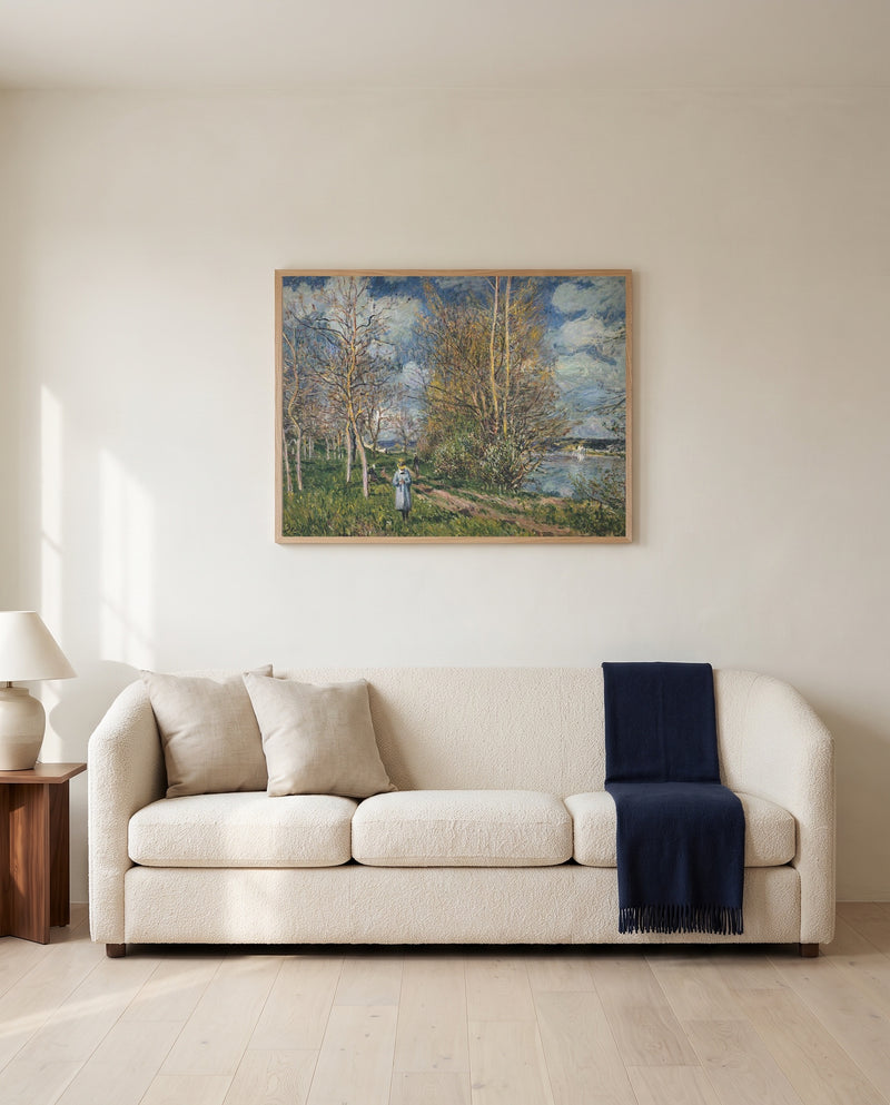 Small Meadows in Spring by Alfred Sisley framed in natural oak above a cream sofa in a warm living room