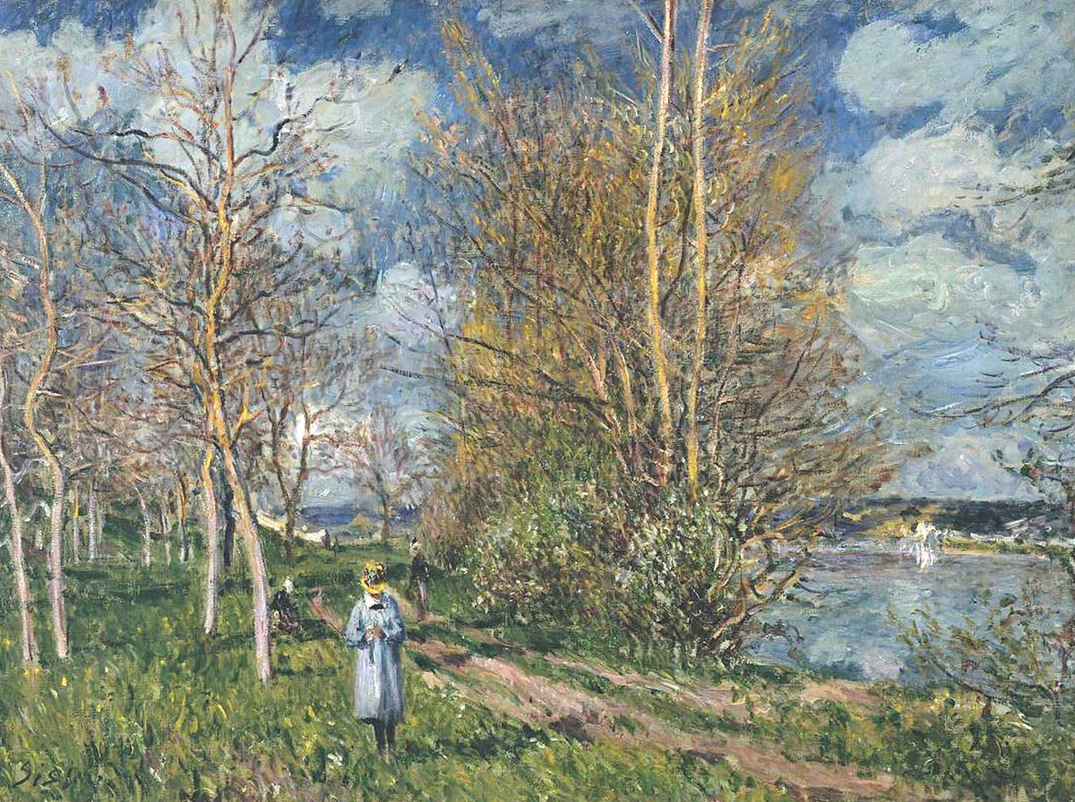 The Small Meadows in Spring by Sisley: young trees along a grassy riverside path, a girl walking, a blue cloudy sky