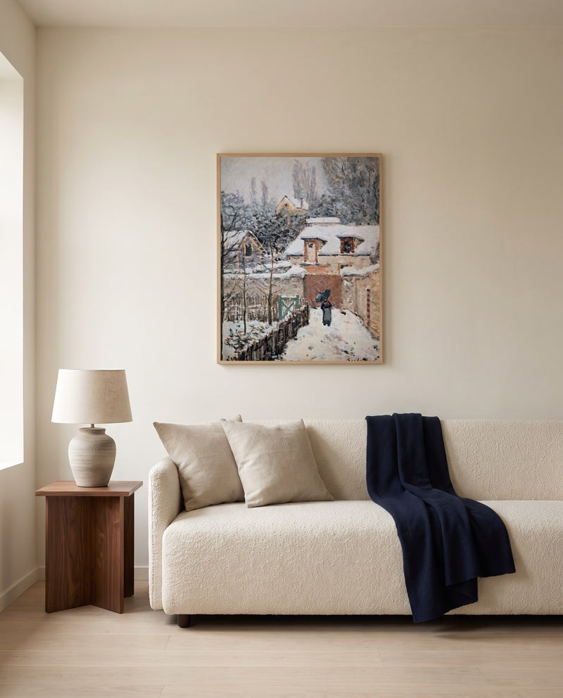 Snow at Louveciennes by Alfred Sisley framed in natural oak above a cream sofa in a warm living room