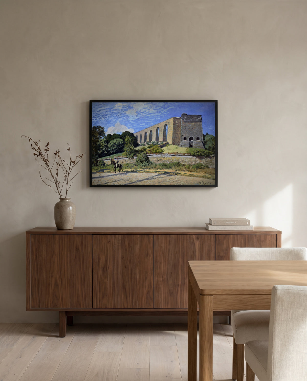 The Aqueduct at Marly by Alfred Sisley in a black frame above a walnut sideboard in a dining room