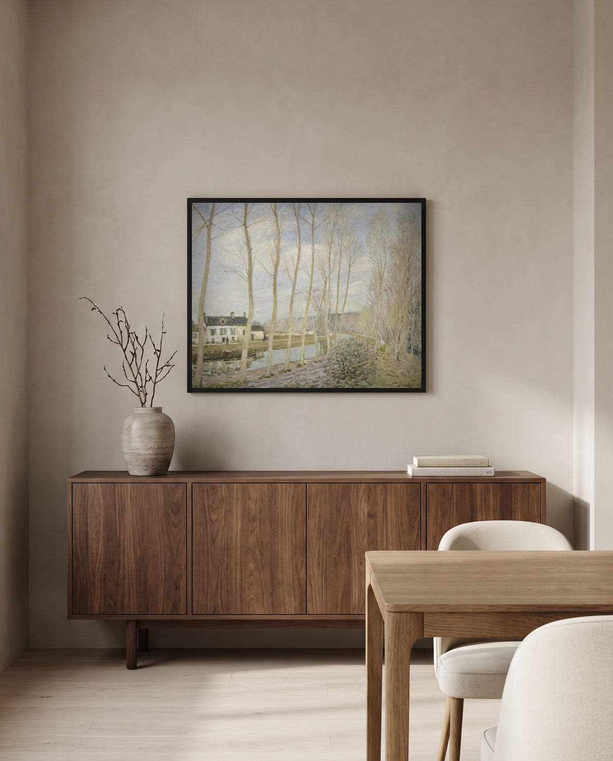 The Canal du Loing by Alfred Sisley in a black frame above a walnut sideboard in a dining room