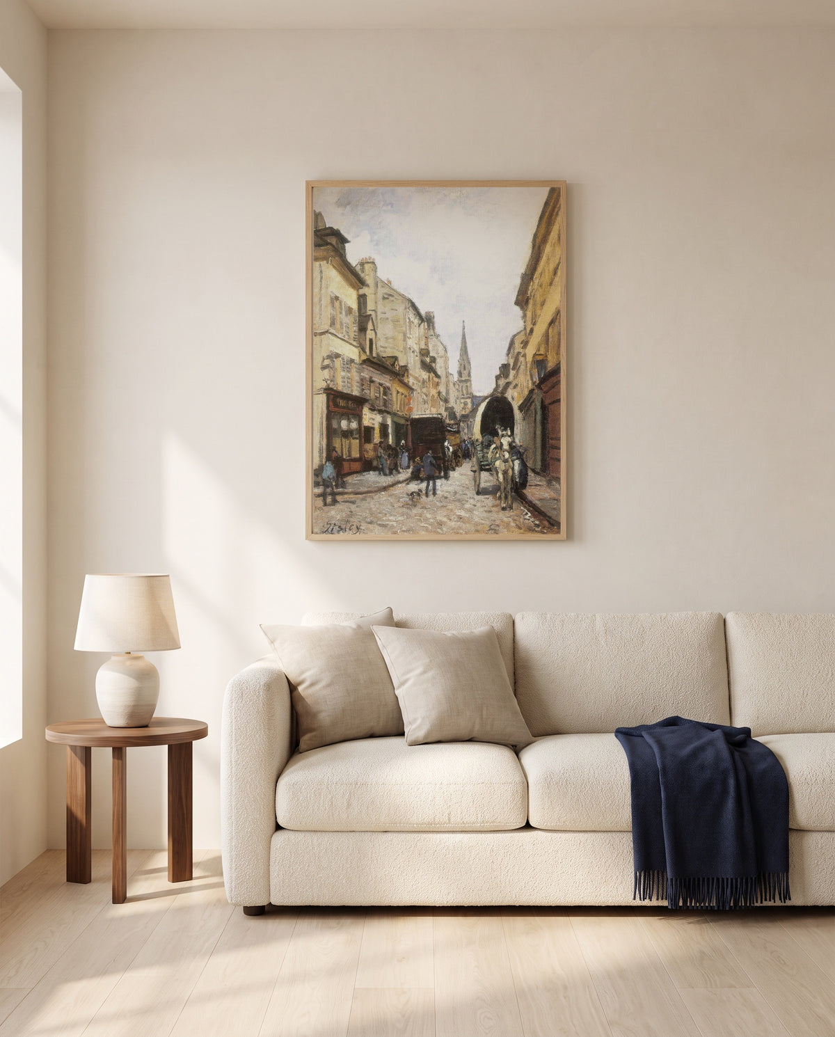 Grand-Rue in Argenteuil by Alfred Sisley framed in natural oak above a cream sofa in a warm living room