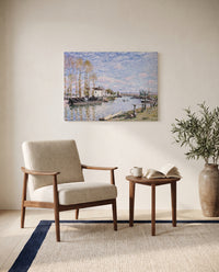 Loing at Saint-Mammès by Alfred Sisley as a stretched canvas above a linen lounge chair in a reading corner