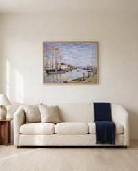 Loing at Saint-Mammès by Alfred Sisley framed in natural oak above a cream sofa in a warm living room