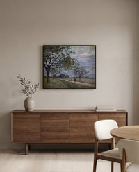 Road to Louveciennes by Alfred Sisley in a black frame above a walnut sideboard in a dining room
