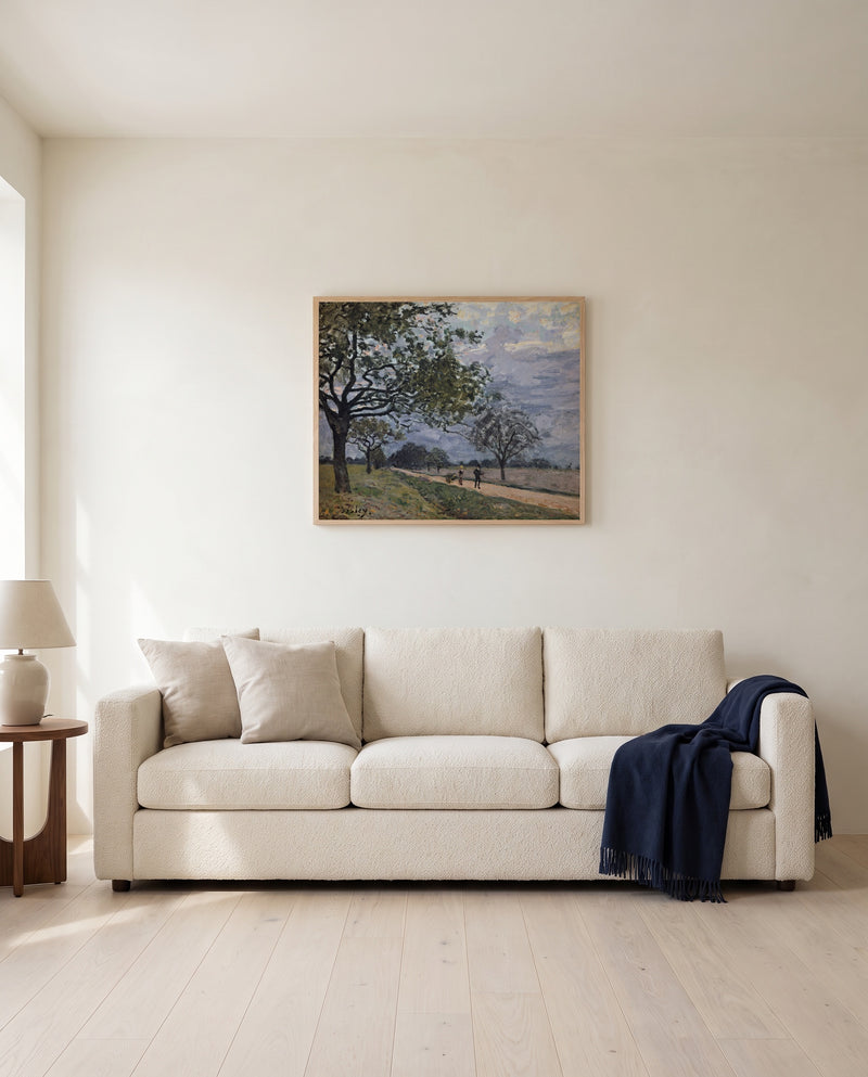 Road to Louveciennes by Alfred Sisley framed in natural oak above a cream sofa in a warm living room
