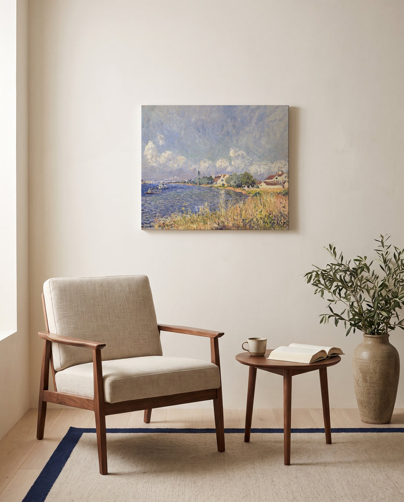 Seine at Billancourt by Alfred Sisley as a stretched canvas above a linen lounge chair in a reading corner