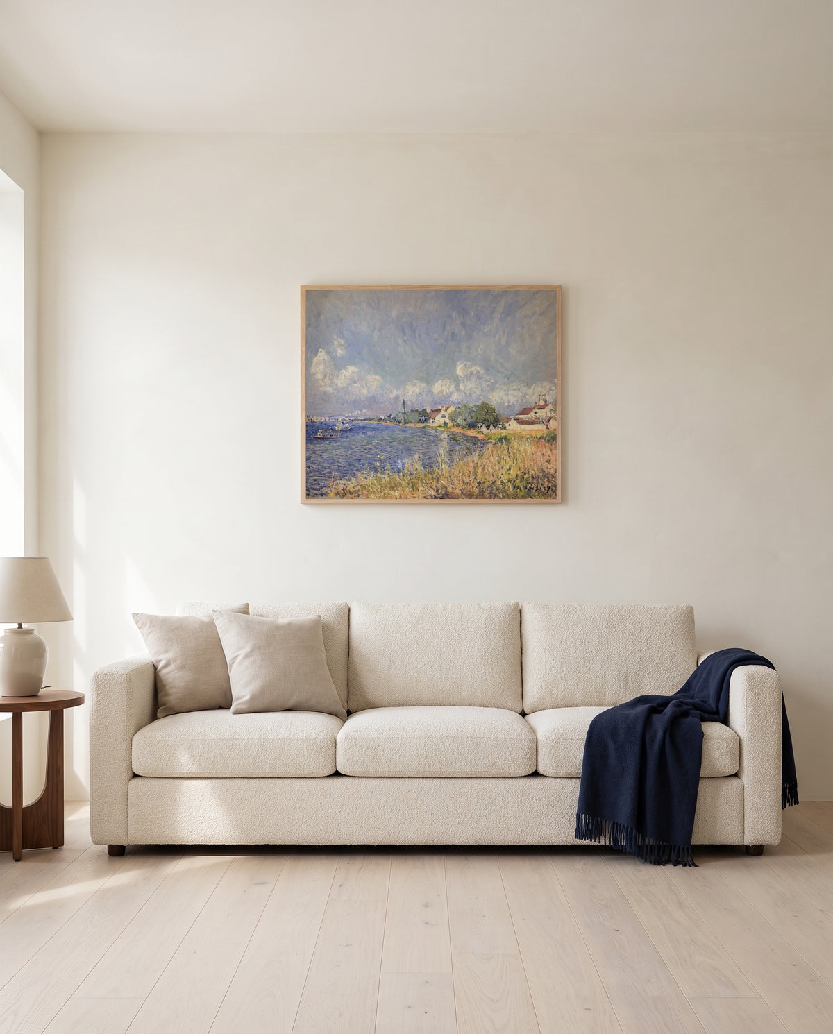 Seine at Billancourt by Alfred Sisley framed in natural oak above a cream sofa in a warm living room