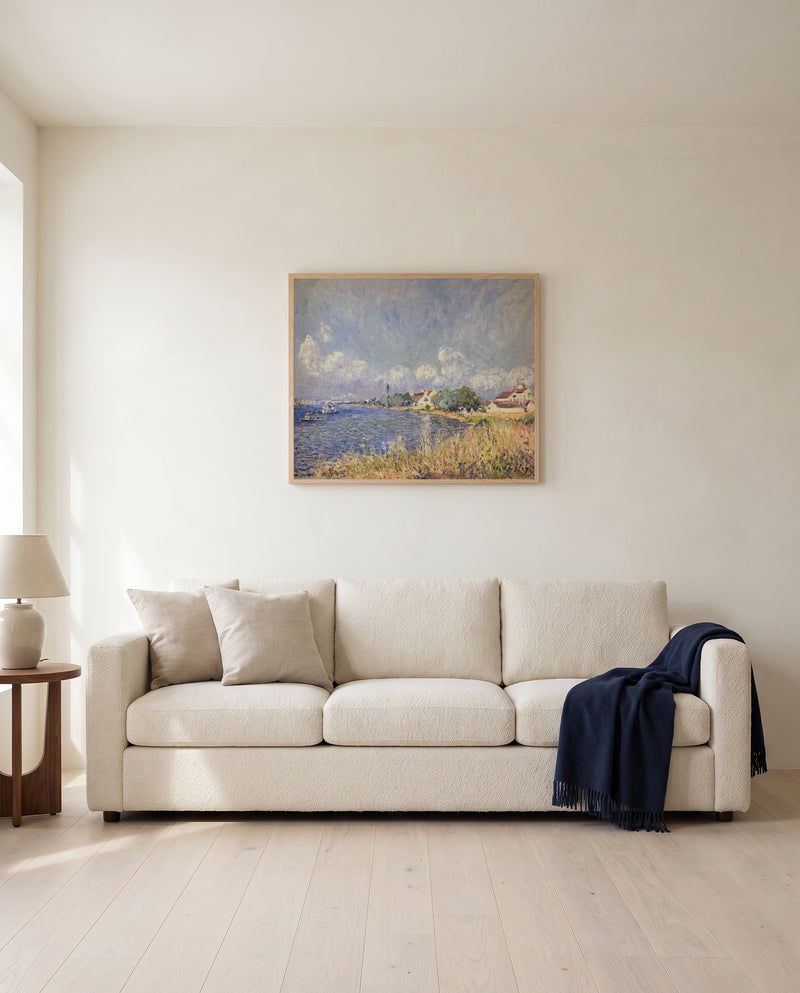 Seine at Billancourt by Alfred Sisley framed in natural oak above a cream sofa in a warm living room