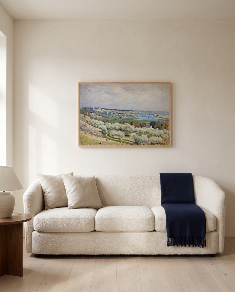 Terrace at Saint-Germain by Alfred Sisley framed in natural oak above a cream sofa in a warm living room