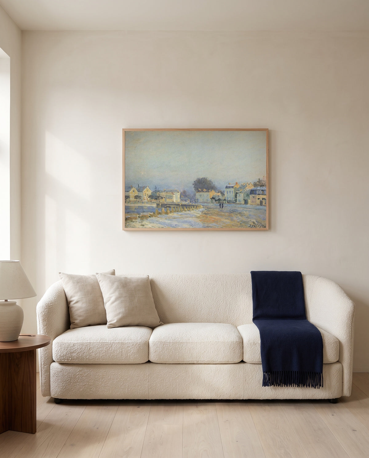 Watering Pond at Marly by Alfred Sisley framed in natural oak above a cream sofa in a warm living room