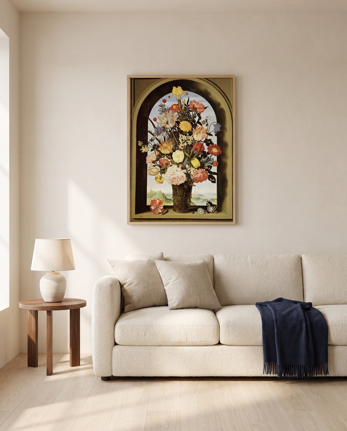 Vase of Flowers in a Niche by Ambrosius Bosschaert the Elder framed in natural oak above a cream sofa in a warm living room