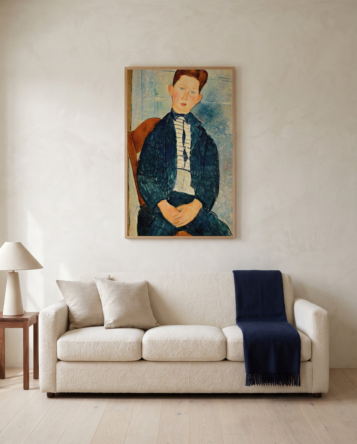 Boy in a Striped Sweater by Amedeo Modigliani framed in natural oak above a cream sofa in a warm living room