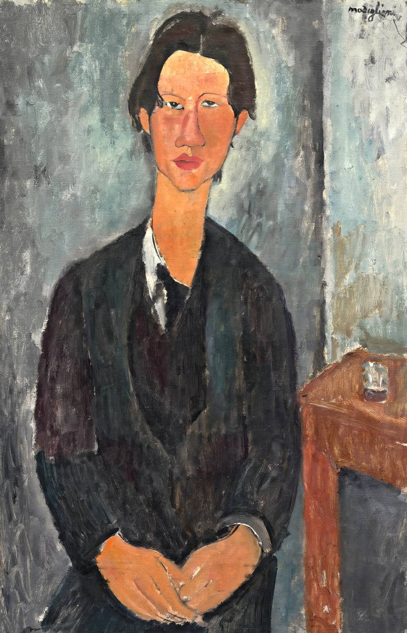 Chaïm Soutine by Modigliani: a young man with dark hair seated in a black coat and teal vest, hands folded, beside a table