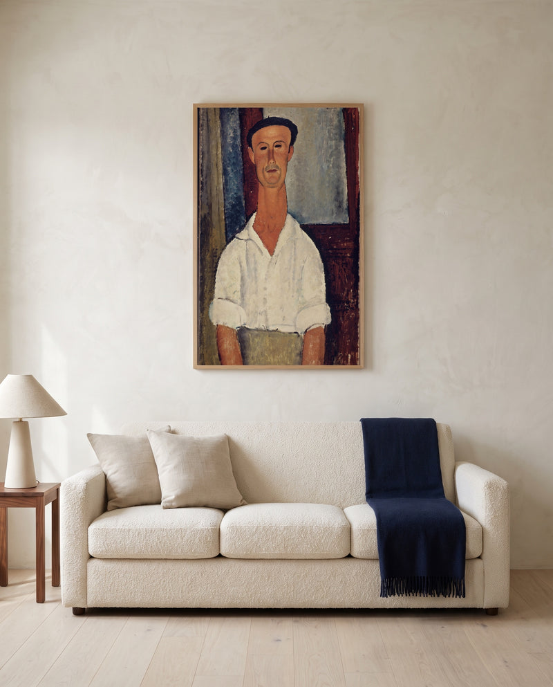 Gaston Modot by Amedeo Modigliani framed in natural oak above a cream sofa in a warm living room