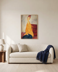 Jeanne in Yellow Sweater by Amedeo Modigliani framed in natural oak above a cream sofa in a warm living room