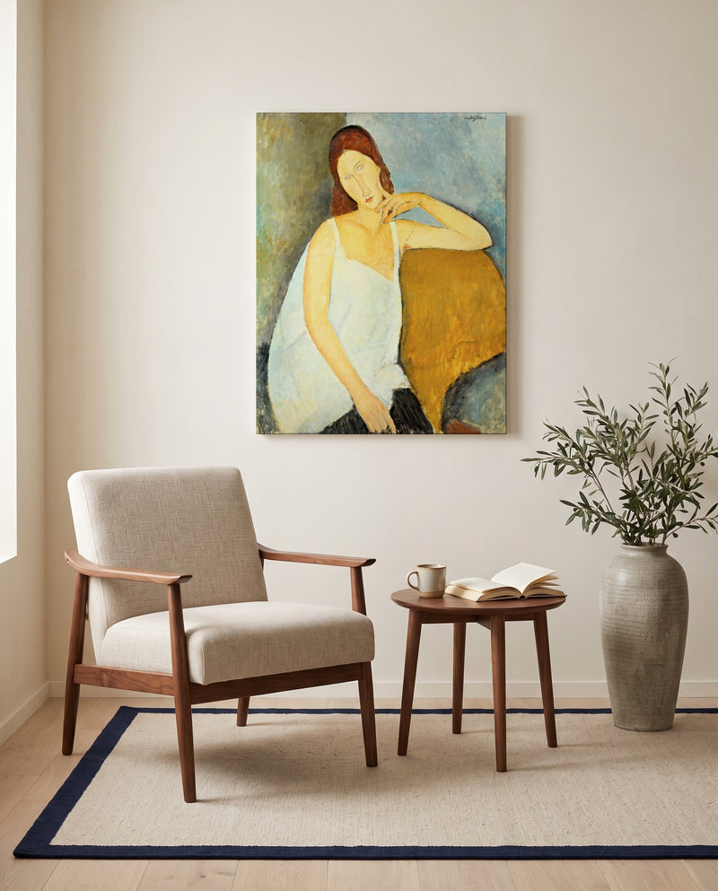 Jeanne Hébuterne (1919) by Amedeo Modigliani as a stretched canvas above a linen lounge chair in a reading corner