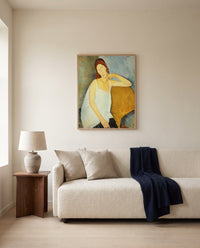 Jeanne Hébuterne (1919) by Amedeo Modigliani framed in natural oak above a cream sofa in a warm living room