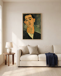 Juan Gris by Amedeo Modigliani framed in natural oak above a cream sofa in a warm living room