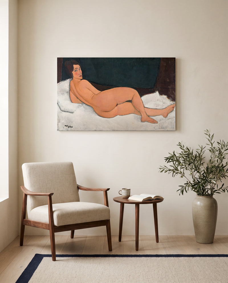 Reclining Nude (Left Side) by Amedeo Modigliani as a stretched canvas above a linen lounge chair in a reading corner