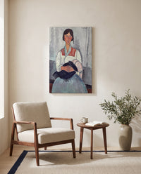 Roma Woman with Baby by Amedeo Modigliani as a stretched canvas above a linen lounge chair in a reading corner