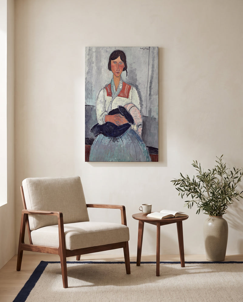 Roma Woman with Baby by Amedeo Modigliani as a stretched canvas above a linen lounge chair in a reading corner