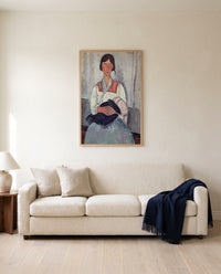 Roma Woman with Baby by Amedeo Modigliani framed in natural oak above a cream sofa in a warm living room