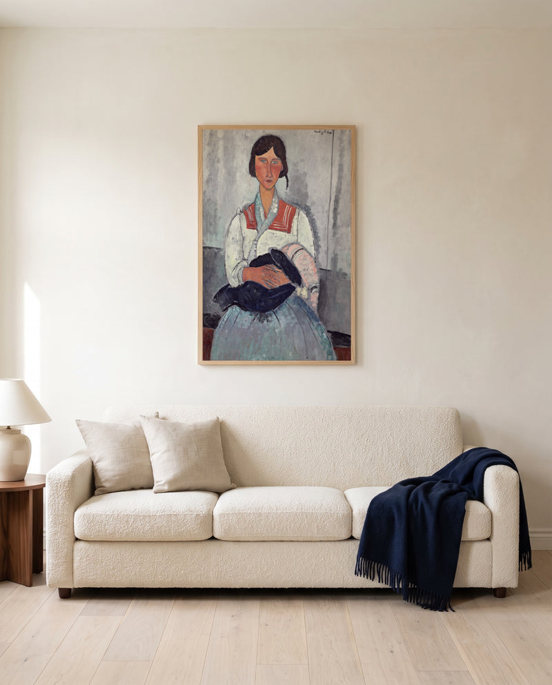 Roma Woman with Baby by Amedeo Modigliani framed in natural oak above a cream sofa in a warm living room