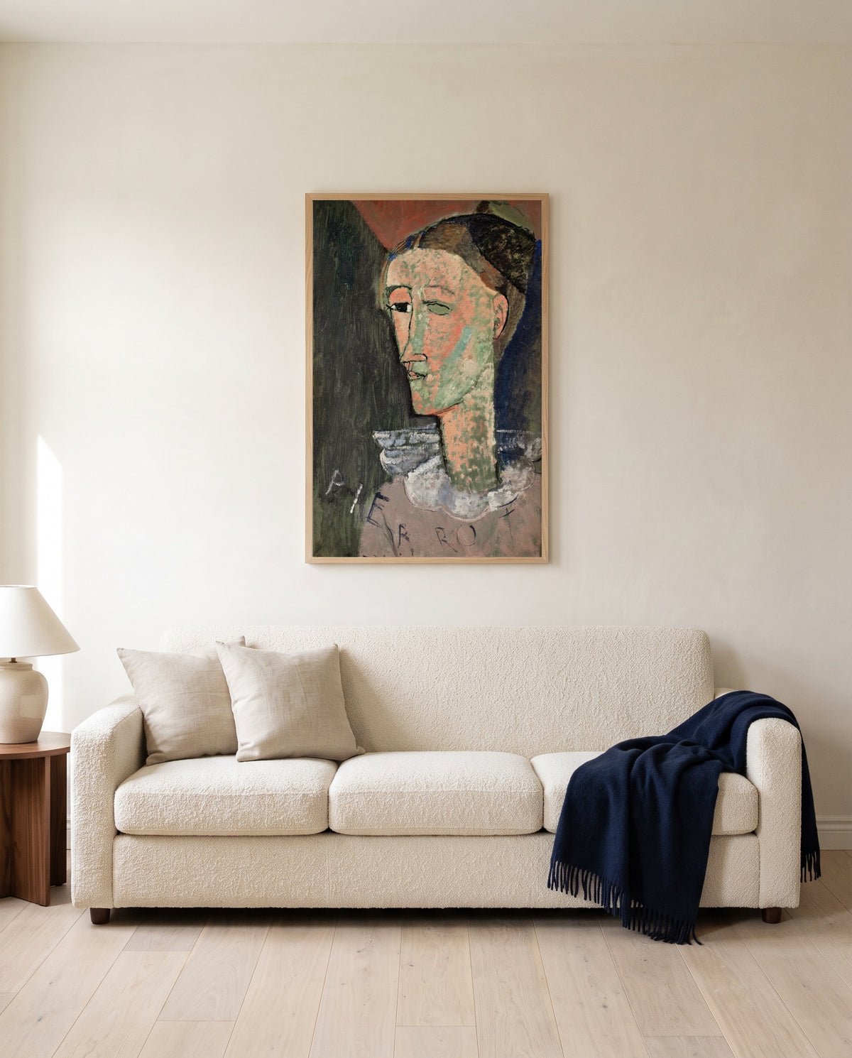 Self-Portrait as Pierrot by Amedeo Modigliani framed in natural oak above a cream sofa in a warm living room