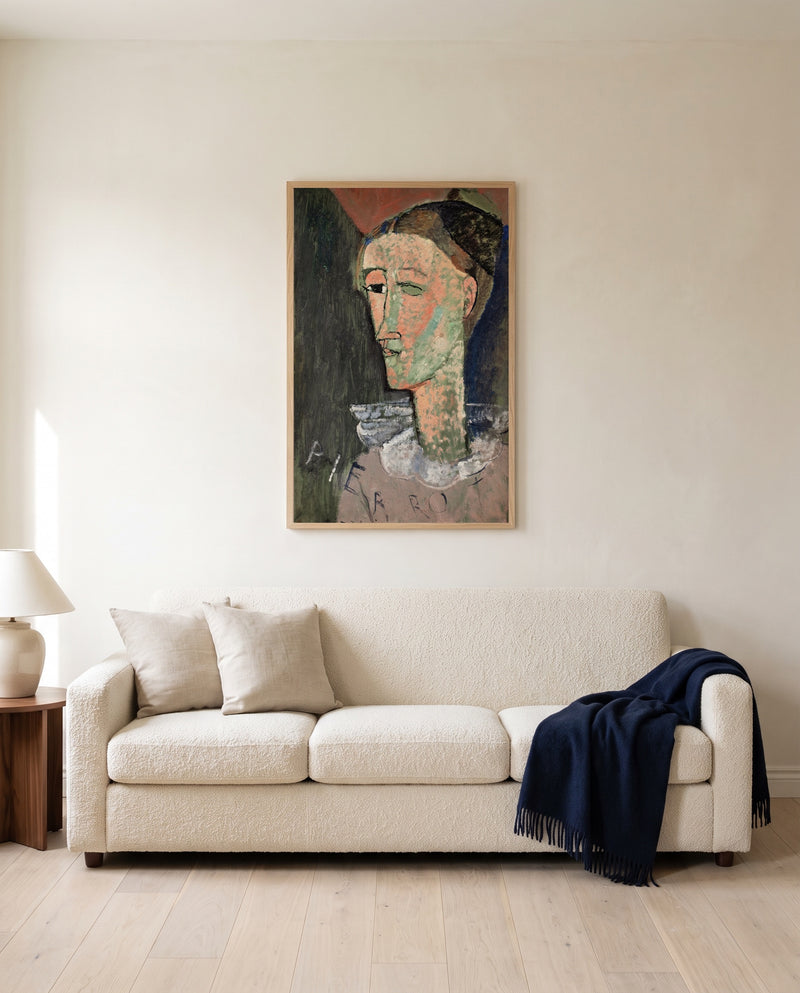 Self-Portrait as Pierrot by Amedeo Modigliani framed in natural oak above a cream sofa in a warm living room