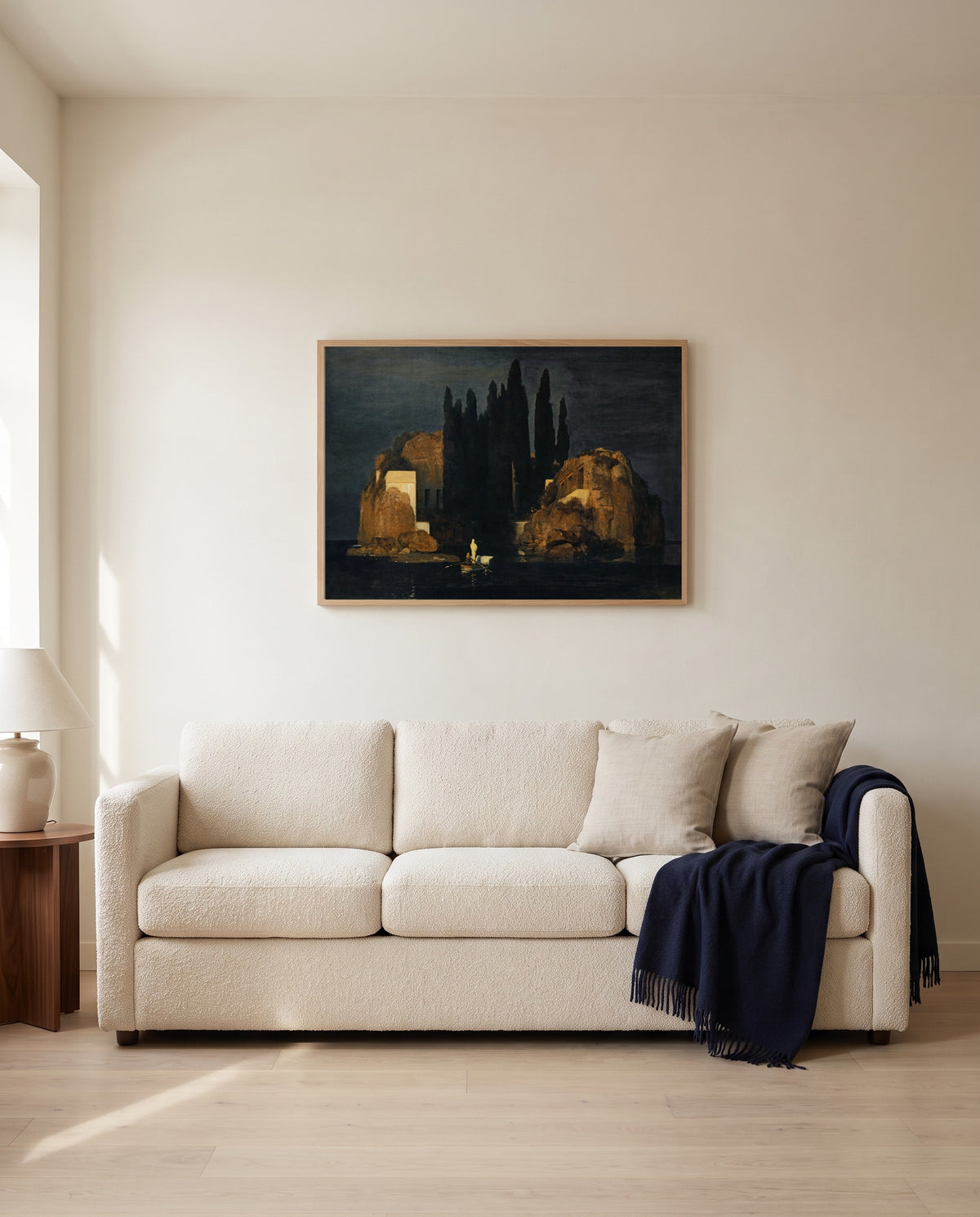 Isle of the Dead (Basel) by Arnold Böcklin framed in natural oak above a cream sofa in a warm living room