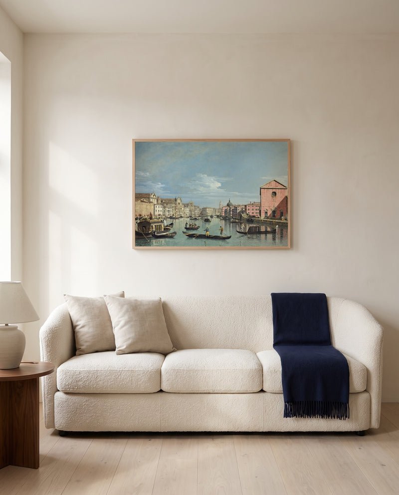 Grand Canal, Santa Croce by Bernardo Bellotto framed in natural oak above a cream sofa in a warm living room